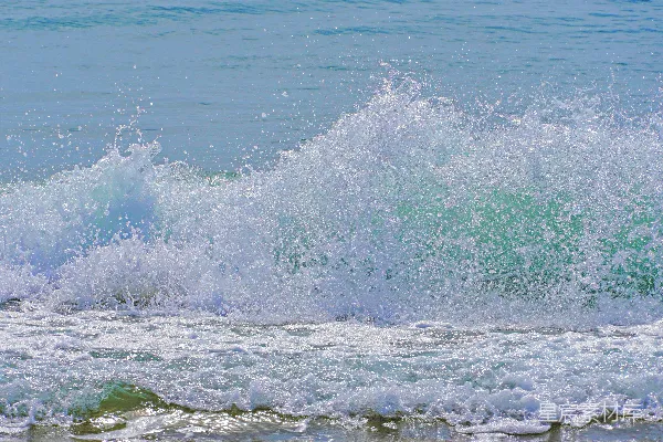 高清摄影 海边一个男子站在冲浪板上享受着海浪的冲刷。
