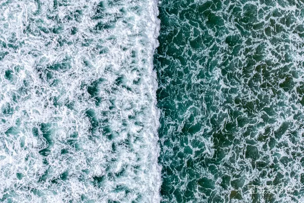 高清摄影 破碎的海浪与波光粼粼的绿水相接。