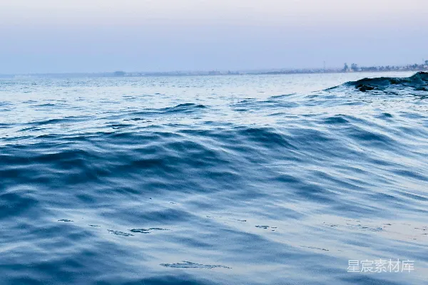 高清摄影 海边一个人坐在冲浪板上在海浪上滑行