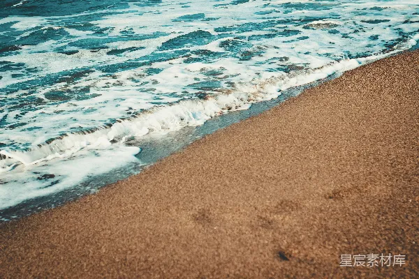 高清摄影 海滩旁边一片金色的沙滩，海浪即将来临。