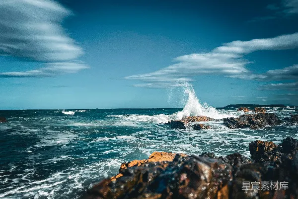 高清摄影 波浪拍打着岩石海岸，在蓝天下涌动。