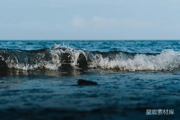 高清摄影 海面上波浪拍打着，在一片晴朗的天空下。