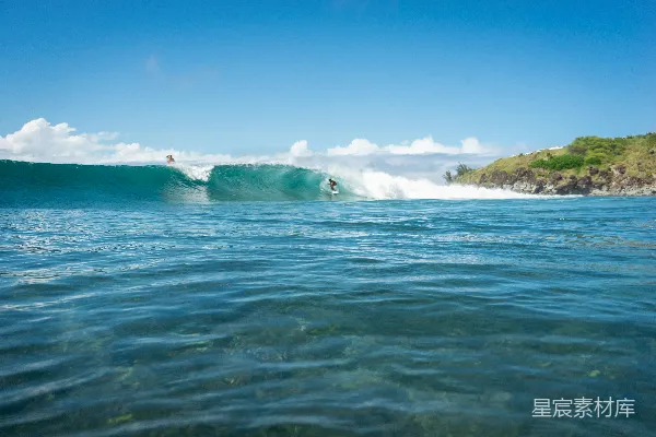 高清摄影 阳光明媚的一天中冲浪者正在一个波峰上 surfing on a breaking wave on a sunny day。