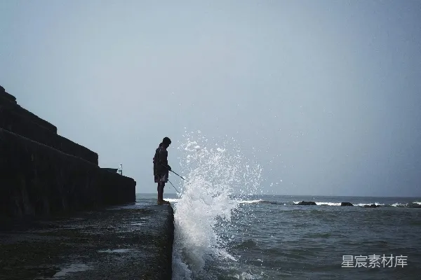 高清摄影 白天一个人站在岩石上近海的轮廓图象
