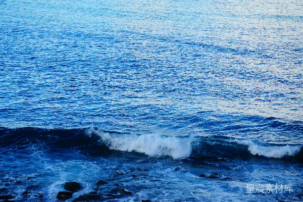 高清摄影 蓝色的大海波浪上泛着白色的泡沫，靠近岸边。