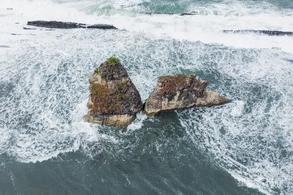 高清摄影 海浪在两块岩石周围翻滚。
