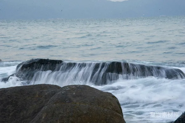 高清摄影 一块大石头坐在一片水域之上。