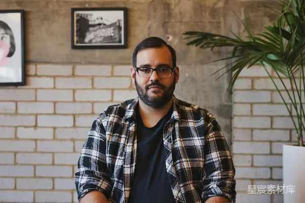 高清摄影 男人自拍穿着灰色和白色的翻领衬衫，旁边有绿色的叶子植物和一个白色陶瓷花盆。