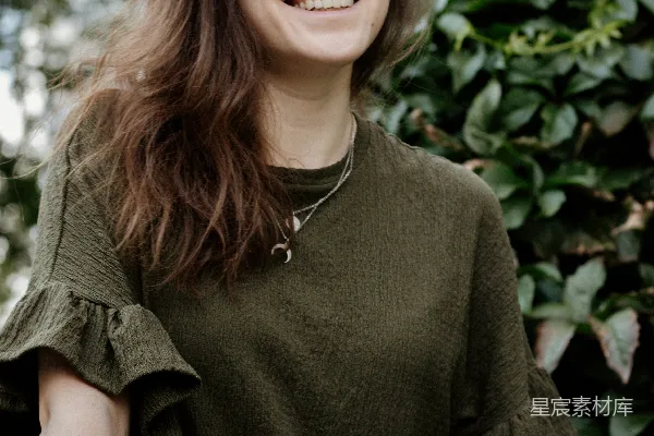 高清摄影 白天穿着绿色圆领T恤的微笑女士站在绿色叶子树旁