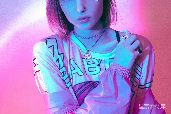 高清摄影 白衬衫配粉衣女子靠近一面白色墙，戴着项链。