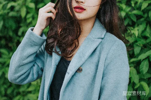 高清摄影 穿灰色外套的女人站在绿色植物旁边