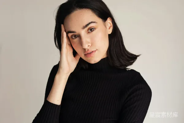 高清摄影 一个穿着黑色毛衣和牛仔裤的女人正在拍照。