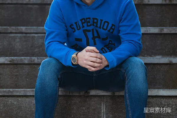 高清摄影 身穿蓝卫衣和蓝色牛仔裤的男人坐在混凝土台阶上