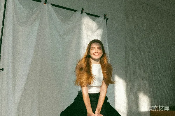 高清摄影 一个微笑的女人在明亮的摄影棚里摆姿势。
