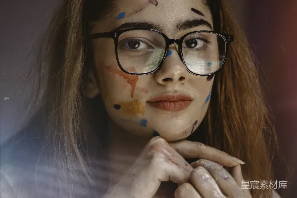 高清摄影 一个戴着眼镜且脸上画有妆容的女人正在拍照。