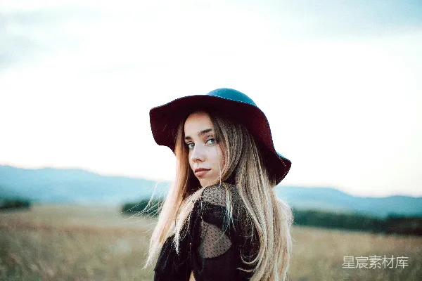 高清摄影 一个长发 blond 的女性戴着帽子。