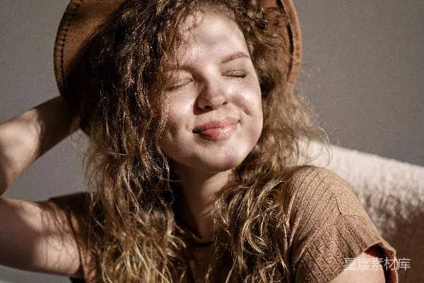 高清摄影 一个披有卷发的女人戴着一顶棕色的帽子