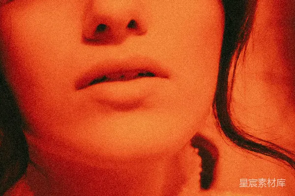 高清摄影 一个穿着红色灯光的女人在对着相机看。