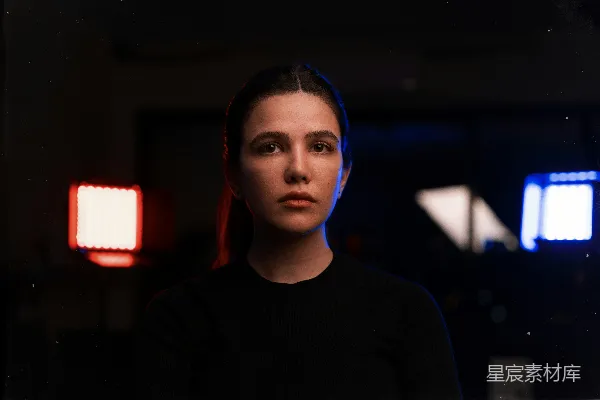 高清摄影 一个女人站在一间黑暗的房间中央，在她面前是一道红色的灯光。