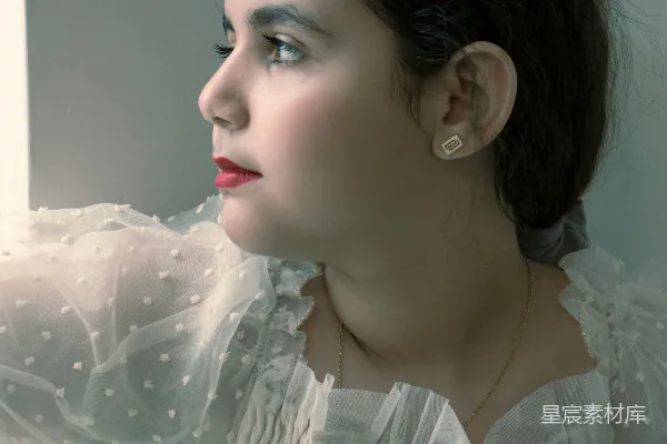 高清摄影 一个穿白色连衣裙的女人望着窗外。