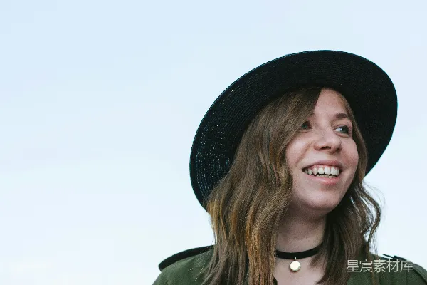 高清摄影 一个女人戴着一顶黑色帽子，穿着一件绿色夹克。