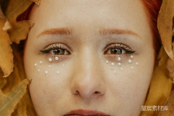 高清摄影 脸上长有白色斑点的女人被树叶包围。