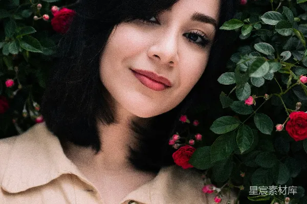 高清摄影 一个女人站在一丛玫瑰花前
