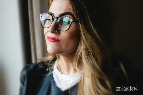 高清摄影 一个戴眼镜的女人望着窗外。