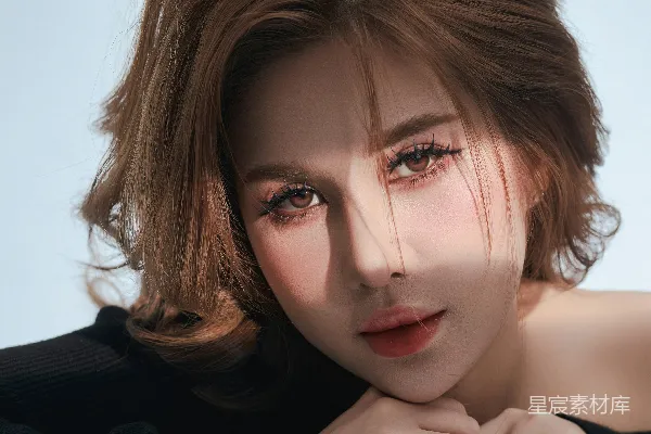 高清摄影 一个女人低头用手掌放在下巴上拍照。