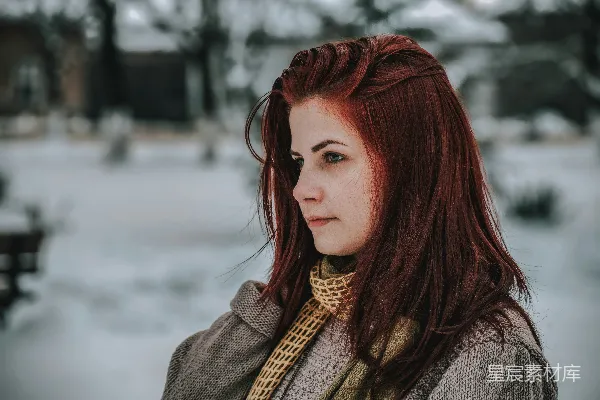 高清摄影 一个红发的女人正站在雪地里。