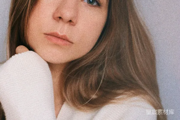 高清摄影 一个穿白色毛衣的女人在拍照。
