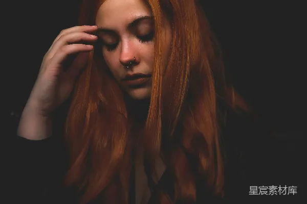 高清摄影 一头红发的女人正捂着自己的头。