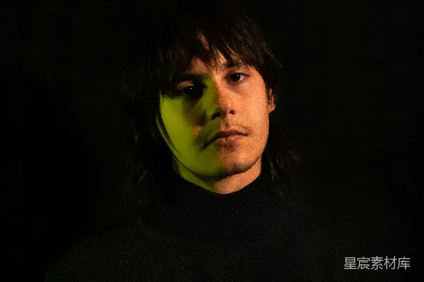 高清摄影 一个身穿黑色衣服的男人脸上散发着绿色的光芒