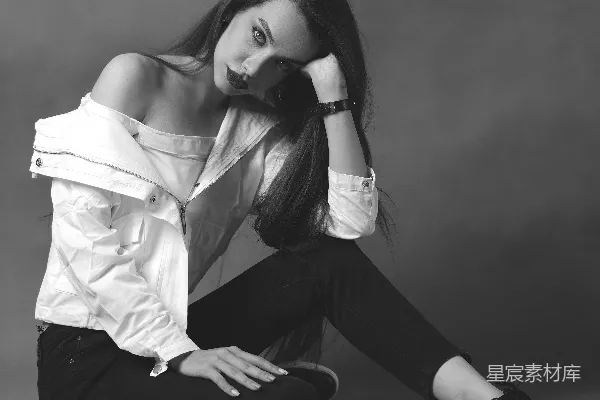 高清摄影 白上衣着装的女性坐在地板上，穿着黑色长裤