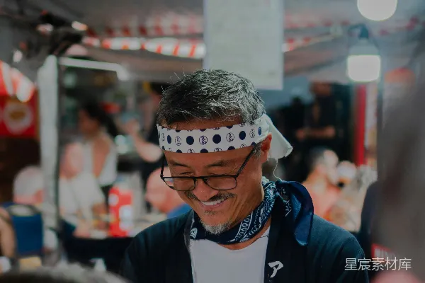 戴着.bandana的男人在户外市场准备食物。