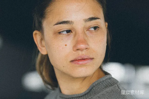 高清摄影 女人若有所思地偏过头，带着中立的表情。