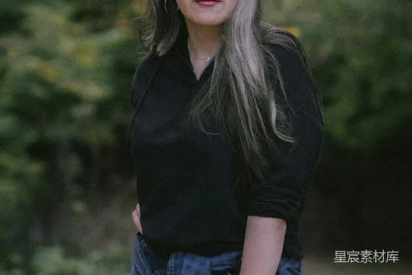 高清摄影 一个女人站在树林里，双手叉腰。