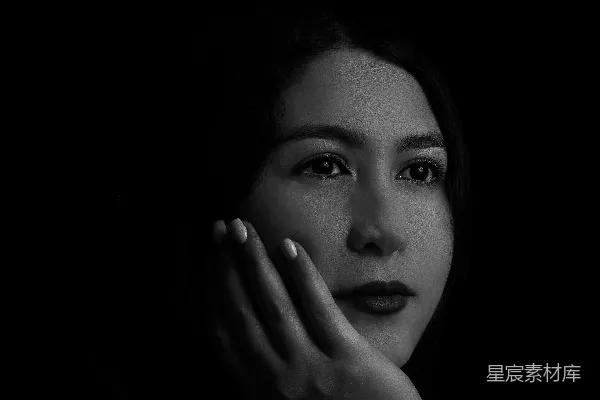 高清摄影 单色的女人向上看着，手放在下巴上。