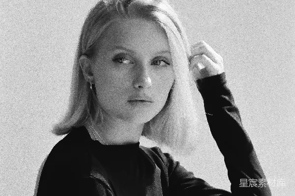 高清摄影 一个穿黑色上衣的 blonde 女人正在触摸她的头发。
