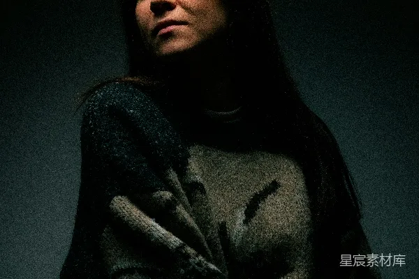 高清摄影 一个女人坐在一间黑暗房间里的椅子上。