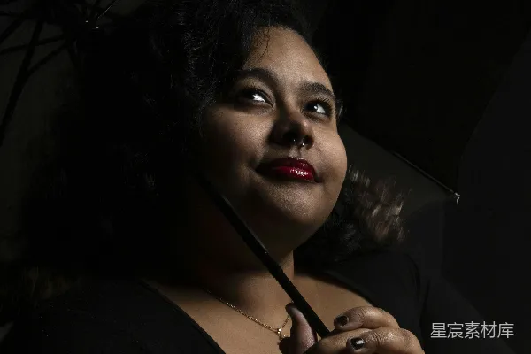 高清摄影 一位女性抬头仰望，手中紧握着一把伞。