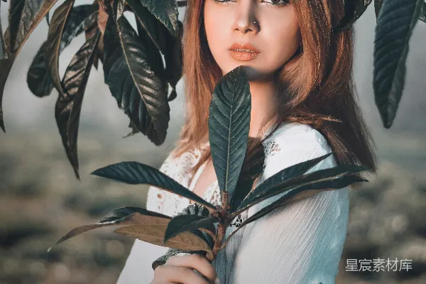 高清摄影 一个女人手里拿着一株植物。