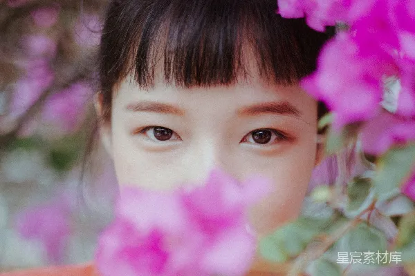 高清摄影 一个头发扎成马尾的女孩，头发上插着粉色的花。