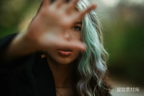 高清摄影 一个绿头发的女人正在做手势。