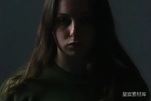 高清摄影 一个穿着绿色毛衣的女人在一间黑暗的房间里