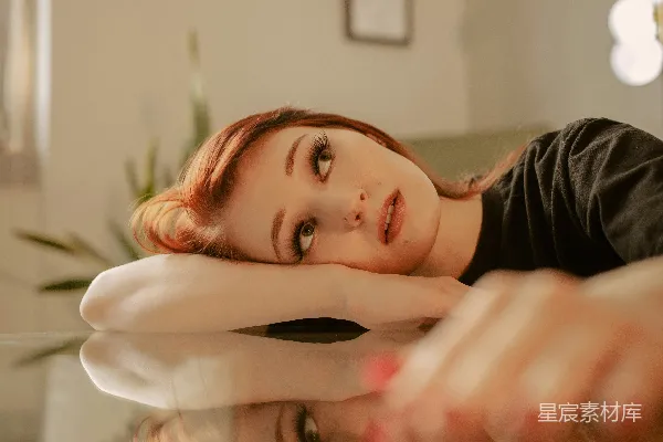 高清摄影 一个女人坐在沙发上，用手捂着脸。