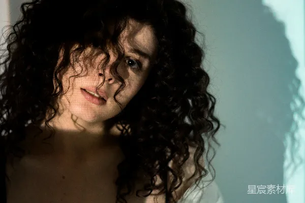 高清摄影 一头 curly 发型的女士在拍照。