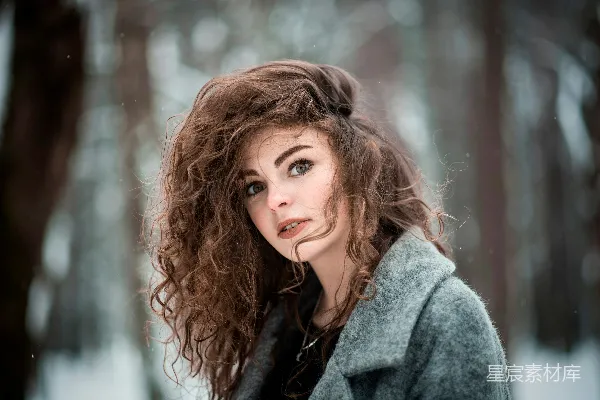 高清摄影 一头 curly 头发的女人站在雪中