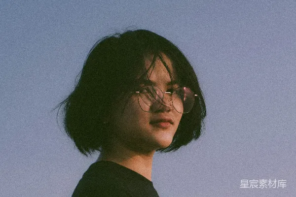 高清摄影 一个戴着眼镜的女人站在蓝天下
