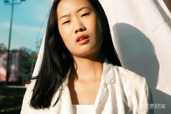 高清摄影 白裙女子站在白帐篷附近，白天站立。